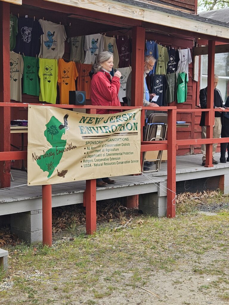 Presenter talking to kids behind banner of New Jersey envirothon